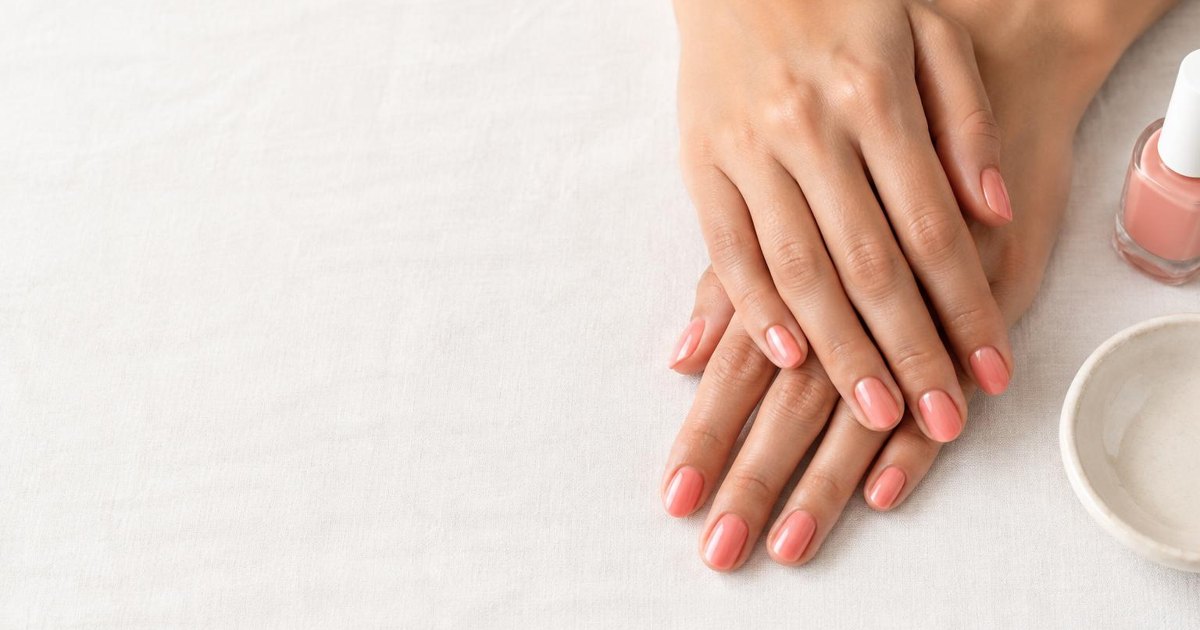 Soft coral gel manicure in natural light